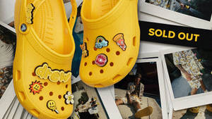 帶有趣味補丁的黃色Crocs展示在拍立得照片和售罄標誌上。 — Crip 壁紙