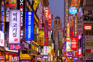黃昏時霓虹燈照亮韓國城市街道，閃爍的招牌和建築物。 — 南韓 壁紙