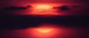 烏雲後水面倒映的紅色太陽，黃昏時分。 — 日落 壁紙