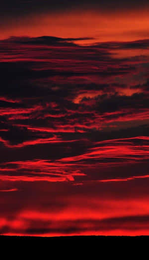 火紅色的雲彩在黑暗地平線之上的黃昏天空中蔓延。 — 日落 壁紙
