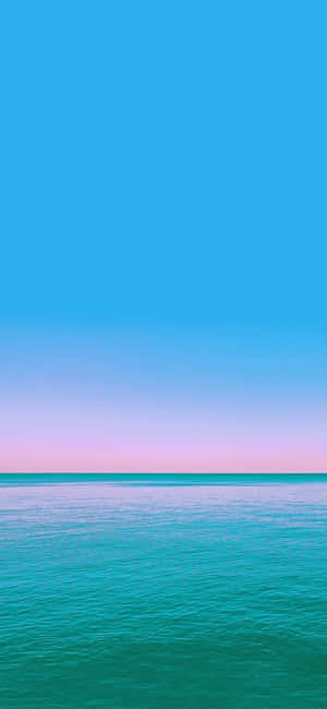 平靜的海洋在暮色地平線上與粉彩天空相遇 — iPhone 13 Mini 壁紙