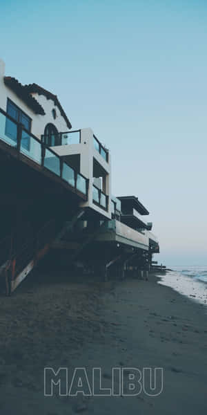 黃昏時分，高蹺上的現代海灘房屋與海浪 — 海灘度假 壁紙