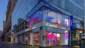 黃昏時分的Capital One Bank店面，色彩繽紛的室內燈光。 — 標誌 壁紙