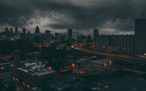 黑暗的暴風雲籠罩著城市景觀，閃爍的路燈和黃昏時分飛馳的車頭燈。