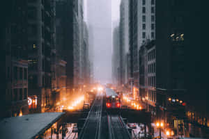 一列紅色火車在黃昏時分滑過雨中的城市街道，街燈閃爍。 — MacBook Air 壁紙