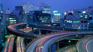 繁華城市黃昏時分，高架高速公路上汽車燈光軌跡。 — 城市風景 壁紙