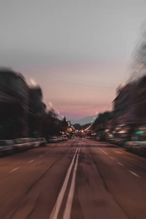 黃昏時分模糊的城市街道，帶有流動燈光和粉紅色的天空。 — 道路 壁紙
