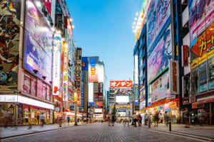 黃昏時分熙攘的東京街頭，發光的動畫廣告牌和行人。 — 城市燈光 壁紙
