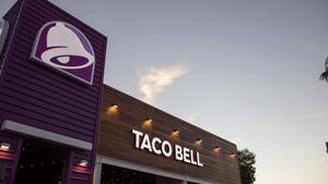 黃昏時分Taco Bell餐廳外觀，紫色與木質立面。 — 塔可 壁紙