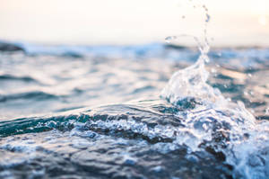 日出時海洋波浪拍打，閃爍的水滴 — 水 壁紙