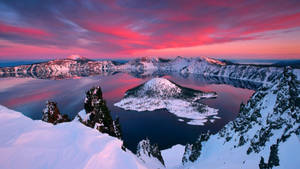 黎明時分白雪覆蓋的火山口湖，粉紅和紫色天空倒映 — 黎明 壁紙