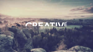 黎明時分霧氣瀰漫的山谷，上面覆蓋著單詞CREATIVE。 — 創意 壁紙