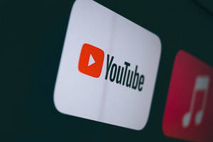 YouTube 應用程式圖示在黑暗的數位螢幕上發光，附近有一個音樂應用程式圖示。 — 標誌 壁紙