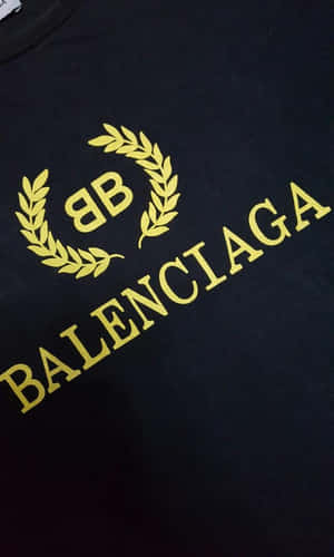 黑色T恤，帶有金色Balenciaga標誌和月桂花環設計。 — Galaxy Tab A11 壁紙