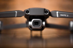 黑色DJI Mavic 2無人機配備Hasselblad相機，置於木質表面的特寫。 — 網路攝影機 壁紙