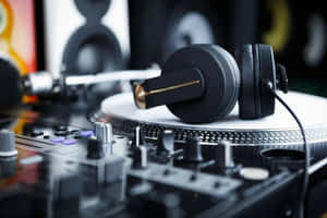 黑色DJ耳機在唱盤上，混音器對焦清晰。 — 音樂美學 壁紙