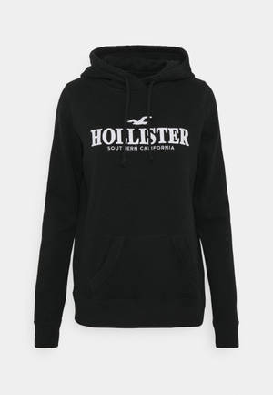 黑色Hollister連帽上衣，帶白色標誌和抽繩。 — 乾淨 壁紙