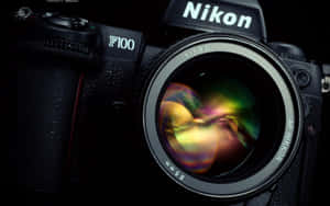Nikon F100相機特寫，帶有彩虹鏡頭光暈。 — 攝影 壁紙