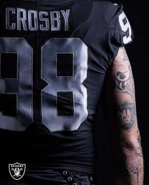 黑色Raiders足球球衣背面，號碼98和名字Crosby，顯示有刺青的手臂。 — 黑色高畫質桌布 壁紙