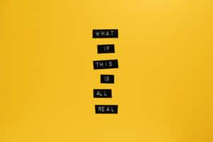 黑色字母瓷磚在黃色牆上拼出「What If This Is All Real」。 — 紋理 壁紙