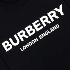 帶有白色 Burberry London England 標誌文字的黑色 T 恤。 — Burberry 壁紙