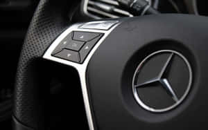 賓士方向盤特寫，帶有控制按鈕和標誌。 — Mercedes Benz C300 壁紙