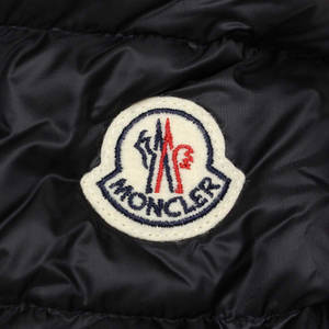 黑色絎縫外套上 Moncler 標誌布章的近距離特寫。 — BLACKPINK 標誌 壁紙