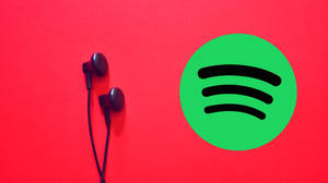 黑色耳機在紅色背景上與Spotify標誌相鄰 — Spotify 壁紙
