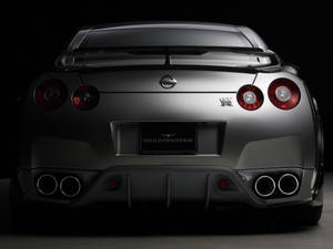 時尚的銀色日產GT-R後視圖，帶有紅色尾燈和四出排氣管。 — 日產GTR 壁紙