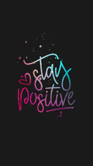 Stay positive 勵志名言，以彩色閃亮字體書寫於黑色背景上。 — 正向 壁紙
