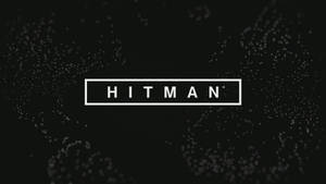 黑色背景上帶有發光粒子的矩形內的白色 HITMAN 文字。 — 電玩遊戲 GIF 壁紙