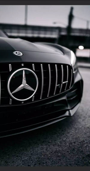 黑色賓士AMG汽車前水箱護罩，在柏油路上帶有鍍鉻細節。 — Mercedes Benz C300 壁紙