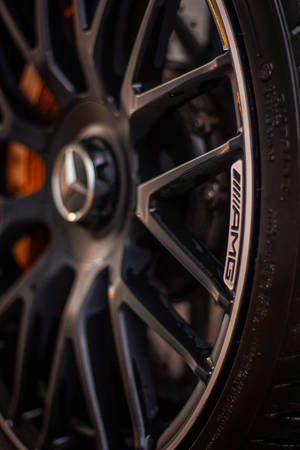 賓士AMG汽車車輪特寫，帶有橙色制動鉗。 — Mercedes Amg iPhone 壁紙