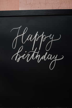黑色黑板上用白色草書寫的 Happy Birthday。 — Huawei MatePad 壁紙